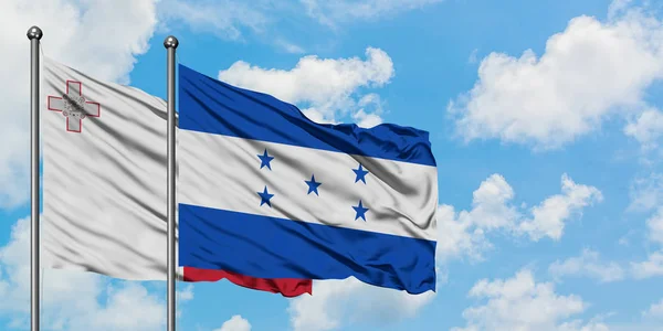 Мальта і Гондурас прапор розмахував вітром проти білого хмарного синього неба разом. Концепція дипломатії, міжнародні відносини. — стокове фото