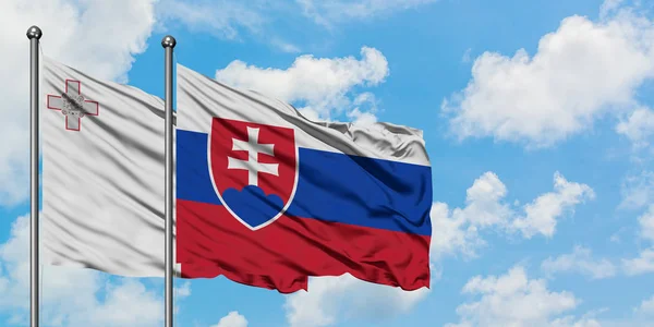 Bandera de Malta y Eslovaquia ondeando en el viento contra el cielo azul nublado blanco juntos. Concepto diplomático, relaciones internacionales . — Foto de Stock