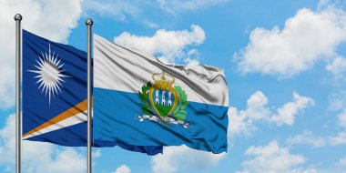 Marshall Adaları ve San Marino bayrağı birlikte beyaz bulutlu mavi gökyüzüne karşı rüzgarda sallayarak. Diplomasi kavramı, uluslararası ilişkiler.