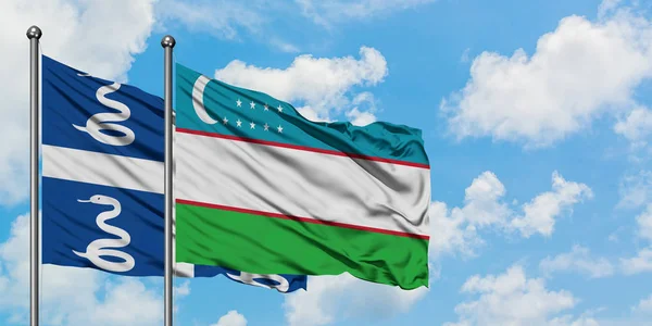 Bandera de Martinica y Uzbekistán ondeando en el viento contra el cielo azul nublado blanco juntos. Concepto diplomático, relaciones internacionales . — Foto de Stock