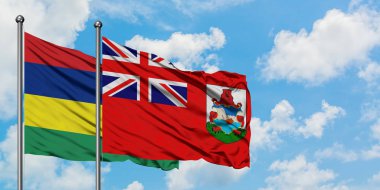 Mauritius ve Bermuda bayrağı birlikte beyaz bulutlu mavi gökyüzüne karşı rüzgarda sallayarak. Diplomasi kavramı, uluslararası ilişkiler.