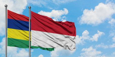 Mauritius ve Monako bayrağı birlikte beyaz bulutlu mavi gökyüzüne karşı rüzgarda sallayarak. Diplomasi kavramı, uluslararası ilişkiler.