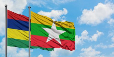 Mauritius ve Myanmar bayrağı birlikte beyaz bulutlu mavi gökyüzüne karşı rüzgarda sallayarak. Diplomasi kavramı, uluslararası ilişkiler.