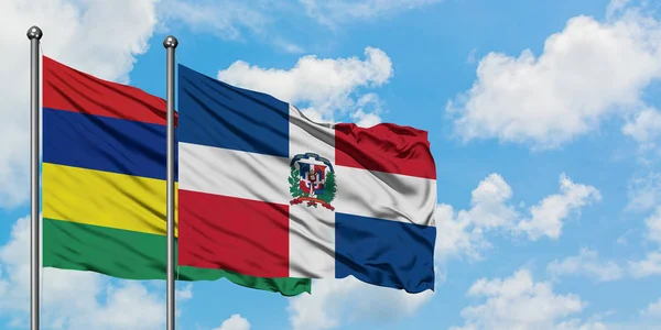 Bandera de Mauricio y República Dominicana ondeando en el viento contra el cielo azul nublado blanco juntos. Concepto diplomático, relaciones internacionales . — Foto de Stock