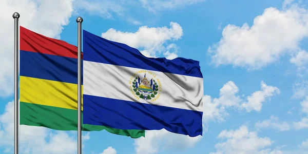 Bandera de Mauricio y El Salvador ondeando en el viento contra el cielo azul nublado blanco juntos. Concepto diplomático, relaciones internacionales . — Foto de Stock