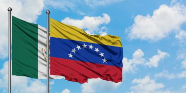 Meksika ve Venezuela bayrağı birlikte beyaz bulutlu mavi gökyüzüne karşı rüzgarda sallayarak. Diplomasi kavramı, uluslararası ilişkiler.