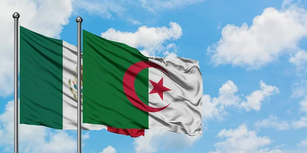 Mexico en Algerije vlag zwaaien in de wind tegen witte bewolkte blauwe hemel samen. Diplomatie concept, internationale betrekkingen. — Stockfoto