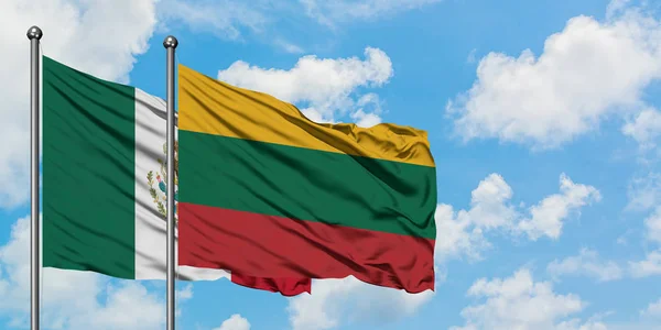 Bandera de México y Lituania ondeando en el viento contra el cielo azul nublado blanco juntos. Concepto diplomático, relaciones internacionales . — Foto de Stock