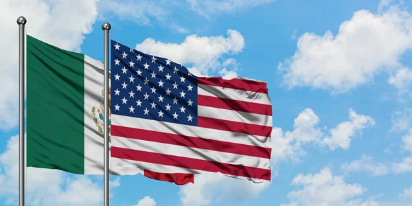 Mexikó és az Egyesült Államok zászló integetett a szél ellen, fehér felhős kék ég együtt. Diplomáciai koncepció, nemzetközi kapcsolatok. — Stock Fotó