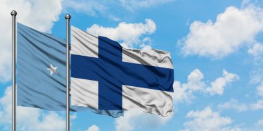 Mikronezya ve Finlandiya bayrağı birlikte beyaz bulutlu mavi gökyüzüne karşı rüzgarsal sallayarak. Diplomasi kavramı, uluslararası ilişkiler.