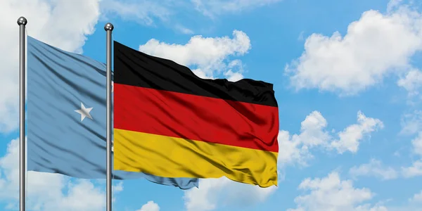 Mikronesien och Tyskland sjunker vifta i vinden mot vit grumlig blå himmel tillsammans. Diplomatisk koncept, internationella relationer. — Stockfoto
