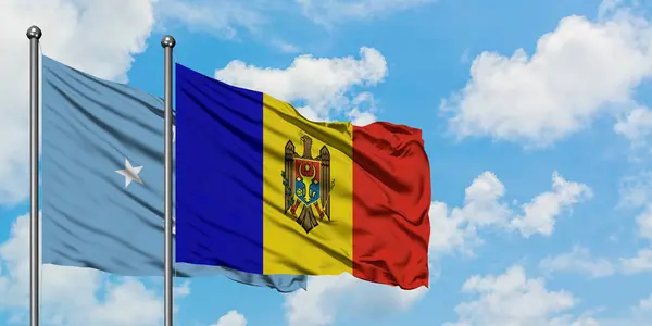 Micronesia en Moldavië vlag zwaaien in de wind tegen witte bewolkte blauwe hemel samen. Diplomatie concept, internationale betrekkingen. — Stockfoto