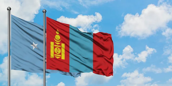 Bandera de Micronesia y Mongolia ondeando en el viento contra el cielo azul nublado blanco juntos. Concepto diplomático, relaciones internacionales . — Foto de Stock