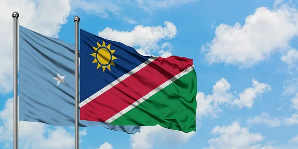 Micronesia en Namibië vlag zwaaien in de wind tegen witte bewolkte blauwe hemel samen. Diplomatie concept, internationale betrekkingen. — Stockfoto