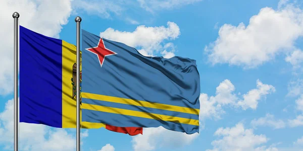 Moldavsko a Arubská vlajka mávali ve větru proti bíle zatažené modré obloze. Diplomacie, mezinárodní vztahy. — Stock fotografie