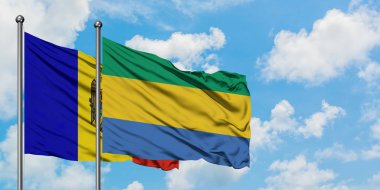 Moldova ve Gabon bayrağı birlikte beyaz bulutlu mavi gökyüzüne karşı rüzgarda sallayarak. Diplomasi kavramı, uluslararası ilişkiler.