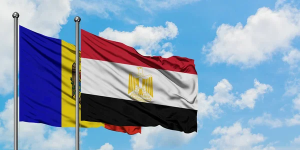 Bandera de Moldavia y Egipto ondeando en el viento contra el cielo azul nublado blanco juntos. Concepto diplomático, relaciones internacionales . — Foto de Stock