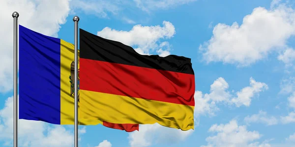 Moldavien och Tyskland sjunker vifta i vinden mot vit grumlig blå himmel tillsammans. Diplomatisk koncept, internationella relationer. — Stockfoto