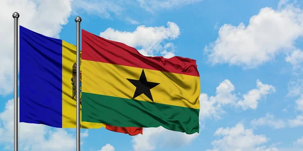 Bandera de Moldavia y Ghana ondeando en el viento contra el cielo azul nublado blanco juntos. Concepto diplomático, relaciones internacionales . — Foto de Stock