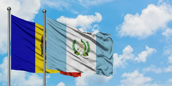 Bandera de Moldavia y Guatemala ondeando en el viento contra el cielo azul nublado blanco juntos. Concepto diplomático, relaciones internacionales . — Foto de Stock
