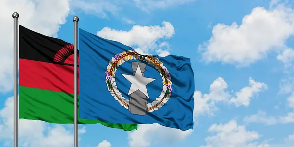 Bandera de Malawi y las Islas Marianas del Norte ondeando en el viento contra el cielo azul nublado blanco juntos. Concepto diplomático, relaciones internacionales . — Foto de Stock