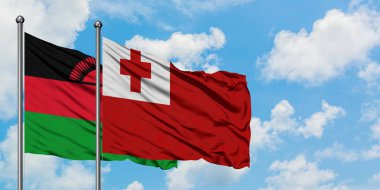 Malavi ve Tonga bayrağı birlikte beyaz bulutlu mavi gökyüzüne karşı rüzgarda sallayarak. Diplomasi kavramı, uluslararası ilişkiler.