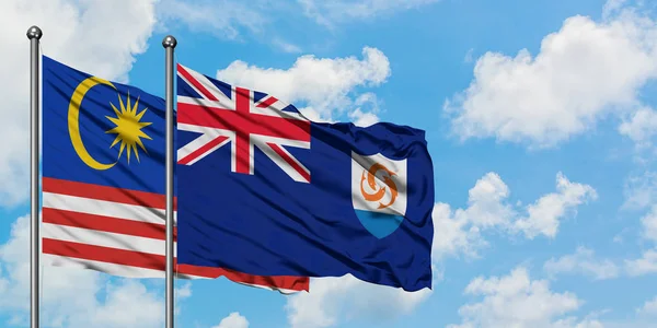 Флаг Малайзии и Ангильи размахивает ветром против белого облачно-синего неба вместе. Концепция дипломатии, международные отношения . — стоковое фото