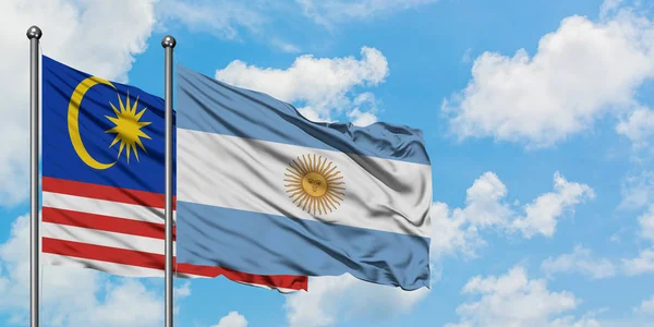 Μαλαισία και Αργεντινή σημαία που κουνώντας τον άνεμο ενάντια λευκό συννεφιασμένο γαλάζιο του ουρανού μαζί. Φιλοσοφία της διπλωματίας, διεθνείς σχέσεις. — Φωτογραφία Αρχείου