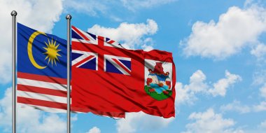 Malezya ve Bermuda bayrağı birlikte beyaz bulutlu mavi gökyüzüne karşı rüzgarda sallayarak. Diplomasi kavramı, uluslararası ilişkiler.