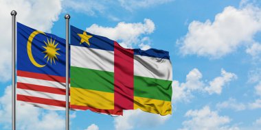 Malezya ve Orta Afrika Cumhuriyeti bayrağı birlikte beyaz bulutlu mavi gökyüzüne karşı rüzgarsal sallayarak. Diplomasi kavramı, uluslararası ilişkiler.