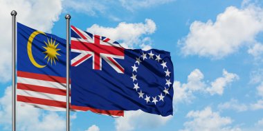 Malezya ve Cook Adaları bayrağı birlikte beyaz bulutlu mavi gökyüzüne karşı rüzgarsal sallayarak. Diplomasi kavramı, uluslararası ilişkiler.