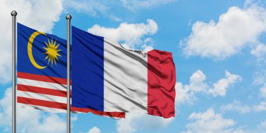 Malezya ve Fransa bayrağı birlikte beyaz bulutlu mavi gökyüzüne karşı rüzgarsal sallayarak. Diplomasi kavramı, uluslararası ilişkiler.