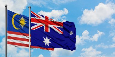 Malezya ve Heard Adası ve Mcdonald Adaları bayrağı birlikte beyaz bulutlu mavi gökyüzüne karşı rüzgarda sallayarak. Diplomasi kavramı, uluslararası ilişkiler.