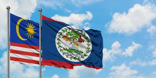 Malezya ve Belize bayrağı birlikte beyaz bulutlu mavi gökyüzüne karşı rüzgarda sallayarak. Diplomasi kavramı, uluslararası ilişkiler.