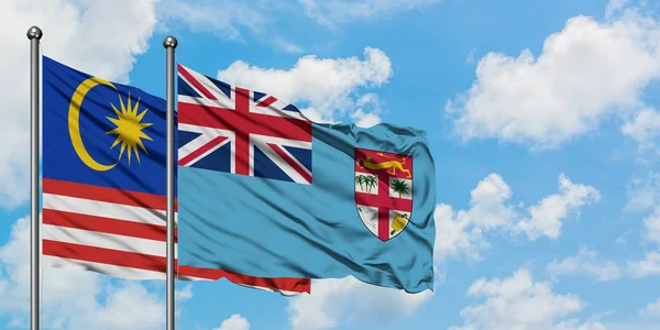 马来西亚和斐济国旗在风中飘扬，与白云蓝天相一起。外交概念、国际关系. — 图库照片