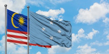 Malezya ve Mikronezya bayrağı birlikte beyaz bulutlu mavi gökyüzüne karşı rüzgarsal sallayarak. Diplomasi kavramı, uluslararası ilişkiler.