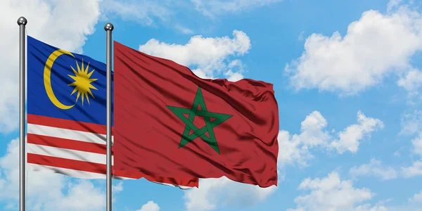 Bandera de Malasia y Marruecos ondeando en el viento contra el cielo azul nublado blanco juntos. Concepto diplomático, relaciones internacionales . — Foto de Stock