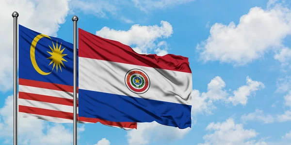 Малайзия и Парагвай вместе машут на ветру белым облачно-голубым небом. Концепция дипломатии, международные отношения . — стоковое фото