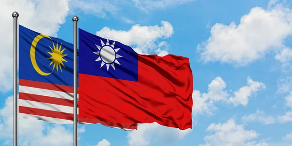 Bandera de Malasia y Taiwán ondeando en el viento contra el cielo azul nublado blanco juntos. Concepto diplomático, relaciones internacionales . — Foto de Stock