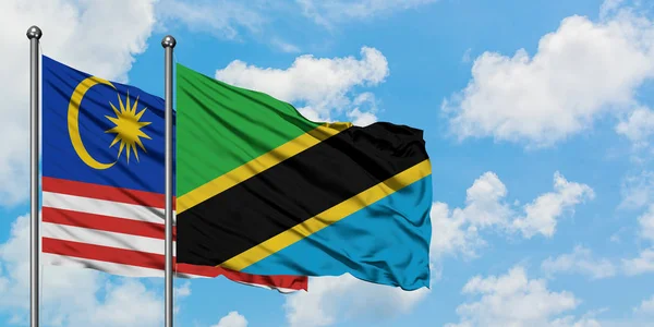 Malaysia and Tanzania flag waving in the wind against white cloudy blue sky together. Diplomacy concept, international relations. — Stock Photo, Image