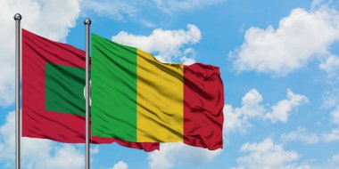 Maldivler ve Mali bayrağı birlikte beyaz bulutlu mavi gökyüzüne karşı rüzgarda sallayarak. Diplomasi kavramı, uluslararası ilişkiler.