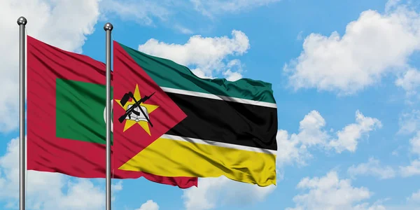 Maldives and Mozambique flag waving in the wind against white cloudy blue sky together. Diplomacy concept, international relations. — Stock Photo, Image