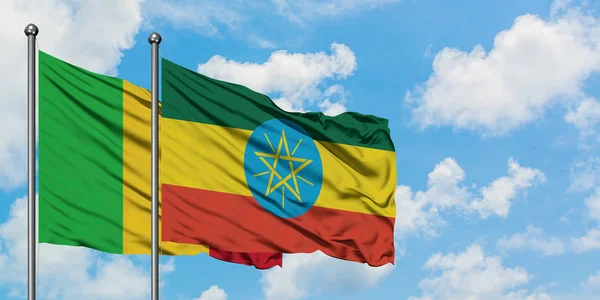 白い曇り青空に向かう風に揺れ続くマリとエチオピアの旗。外交概念、国際関係. — ストック写真
