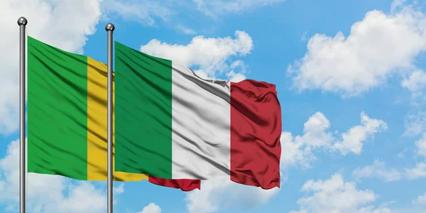 Bandera de Malí e Italia ondeando en el viento contra el cielo azul nublado blanco juntos. Concepto diplomático, relaciones internacionales . — Foto de Stock