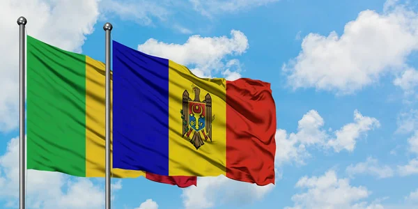 Mali en Moldavië vlag zwaaien in de wind tegen witte bewolkte blauwe hemel samen. Diplomatie concept, internationale betrekkingen. — Stockfoto