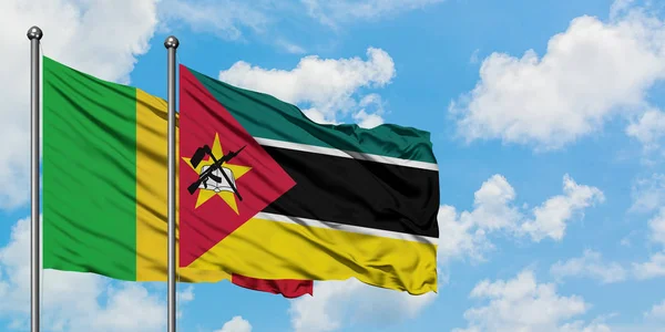 白い曇り青空に向かう風に揺れながら手を振るマリとモザンビークの旗。外交概念、国際関係. — ストック写真