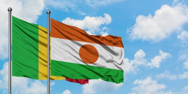 Mali ve Nijer bayrağı birlikte beyaz bulutlu mavi gökyüzüne karşı rüzgarda sallayarak. Diplomasi kavramı, uluslararası ilişkiler.