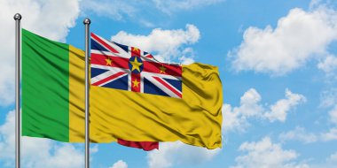 Mali ve Niue bayrağı birlikte beyaz bulutlu mavi gökyüzüne karşı rüzgarda sallayarak. Diplomasi kavramı, uluslararası ilişkiler.