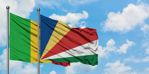 Mali és a Seychelle-szigetek zászló integetett a szél ellen, fehér felhős kék ég együtt. Diplomáciai koncepció, nemzetközi kapcsolatok. — Stock Fotó