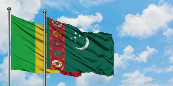 Bandera de Malí y Turkmenistán ondeando en el viento contra el cielo azul nublado blanco juntos. Concepto diplomático, relaciones internacionales . — Foto de Stock